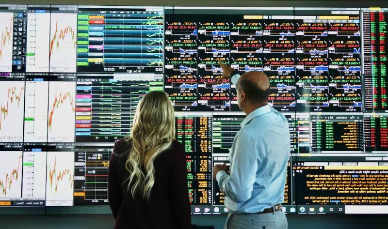 Professor teaching students at the technology wall. 